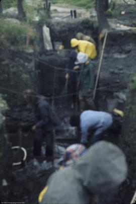 Crew excavating waterlogged deposit from [east]