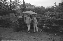 Archaeologists standing under umbrella at Locarno Beach site